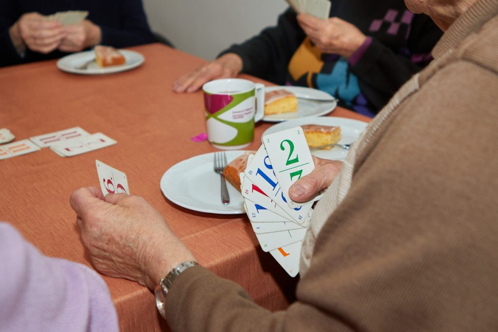 Besucher spielen Karten am Tisch nach dem Mittagessen